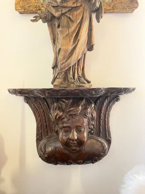 a statue of a woman holding a cross on a wall