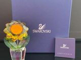 un vase en verre avec une fleur à l'intérieur sur une table