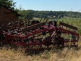 un banc posé au milieu d'un champ, près d'un bâtiment