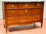 une commode en bois avec un plateau en marbre dans une pièce