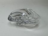 une sculpture en verre représentant une vague sur une surface blanche