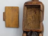 a small wooden box with a small wooden figure on top of it