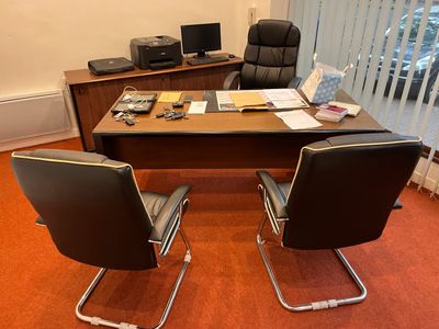 un bureau avec deux chaises et un ordinateur dessus