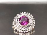 bague en argent avec une pierre rose entourée de diamants sur un fond noir