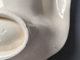 a close up of a white vase with a spoon in it