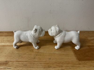 two figurines of two dogs on a wooden table