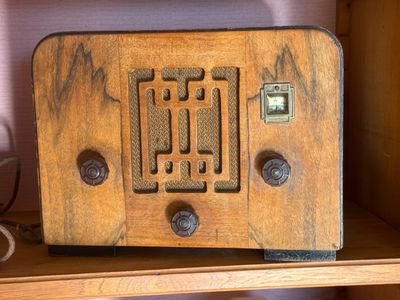 an old radio sitting on a shelf in a room