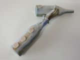a blue and white toothbrush and a bottle on a white surface