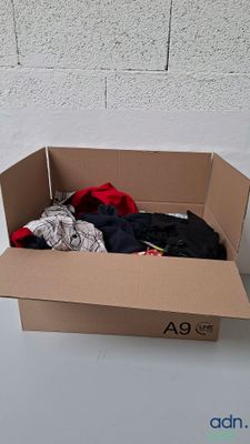 une boîte en carton contenant des vêtements, posée sur une table