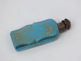 a small blue bottle with a gold design on it