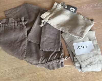 deux paires de pantalons, encore étiquetées, posées sur un parquet