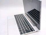 a white laptop with a black keyboard on a white surface