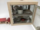a small cabinet with pots and pans inside of it