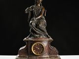 a statue of a woman sitting on top of a clock