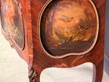 a wooden cabinet with a painting on it
