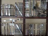 many different types of silverware in a display case