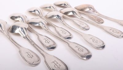six cuillères et deux cuillères en argent sur une surface blanche