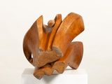 a wooden sculpture on a white pedestal with a white background