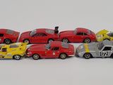 several toy cars are lined up in a row on a white surface