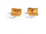 a pair of gold cufflinks on a white background