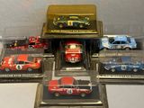 five different model cars in a display case on a table