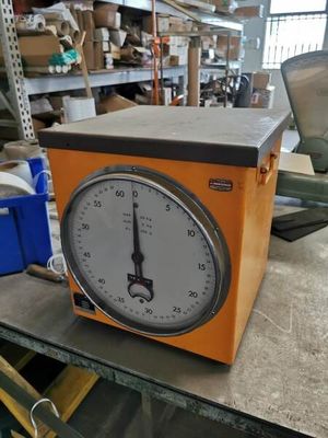 a clock sitting on top of a table in a warehouse