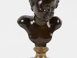 a bronze bust of a boy on a marble base