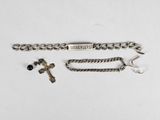 a close up of a chain bracelet with a cross on it
