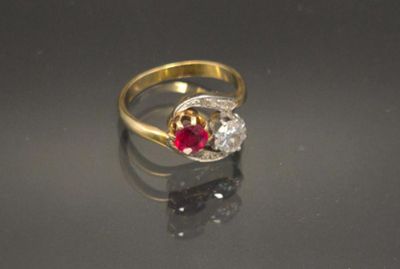 a close up of a gold ring with a red and white stone