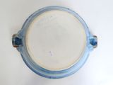 a blue and white bowl with a handle on a white table