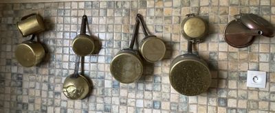 de nombreuses casseroles et poêles accrochées au mur de la cuisine