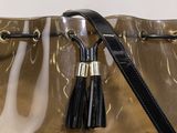 black and gold handbag with tassels hanging from it ' s handle