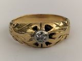 a close up of a gold ring with a diamond in the center