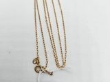 a close up of a necklace with a tag attached to it