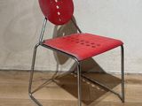 une chaise rouge posée sur un parquet en bois dur