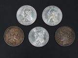 four different types of coins sitting on top of a black surface