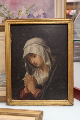 un tableau représentant une femme tenant un bébé dans ses bras, dans un cadre doré