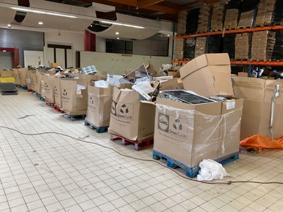 de nombreux cartons posés à même le sol dans l'entrepôt