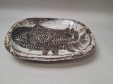 a plate with a fish design on it on a table