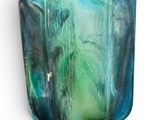 a glass vase with a green and blue design on it