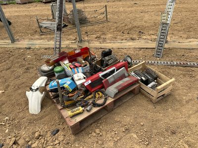 un tas d'outils posé sur une palette en bois, dans la poussière