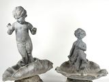 deux statues représentant un garçon et une fille assis sur un coquillage