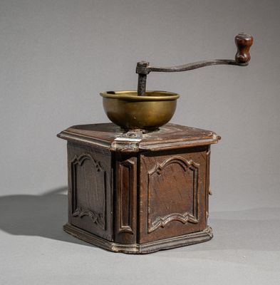 a small wooden grinder with a brass bowl on top of it