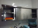 une armoire en acier inoxydable au-dessus d'un évier dans une cuisine