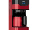 a red coffee maker sitting on top of a white surface