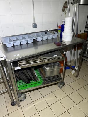 a kitchen with a stainless steel work table and pots and pans on it