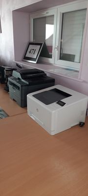 une imprimante posée sur un bureau dans un coin de la pièce