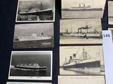 some old photos of ships are on display on a table