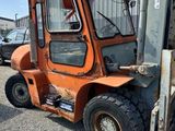 an orange fork truck parked in front of a building