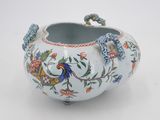 a white vase with blue and red flowers and birds on it